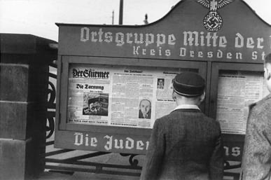 Boys standing in front of a Stürmerkasten, the public stands in cities featuring Der Stürmer during the Nazi era.
